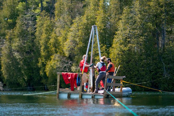 Une équipe de scientifiques récupère une sonde au fond du lac Crawford lors de la collecte d'échantillons de couches de sédiments au lac Crawford près de Milton (Ontario), Canada, le 12 avril 2023. 