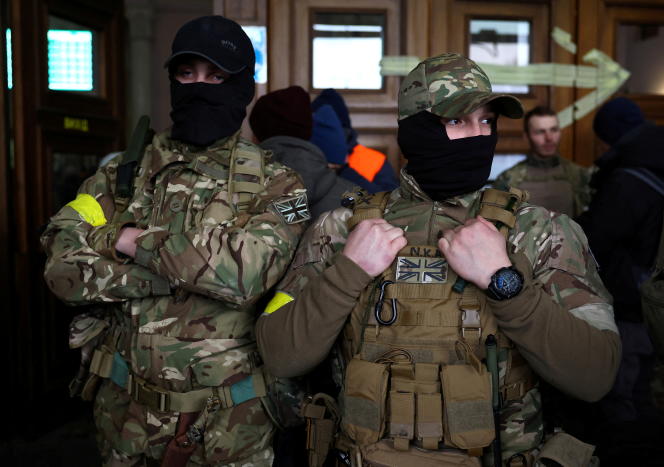 Deux combattants étrangers originaires du Royaume-Uni posent avant de partir vers la ligne de front dans l’est de l’Ukraine, à la gare de Lviv, le 5 mars 2022.