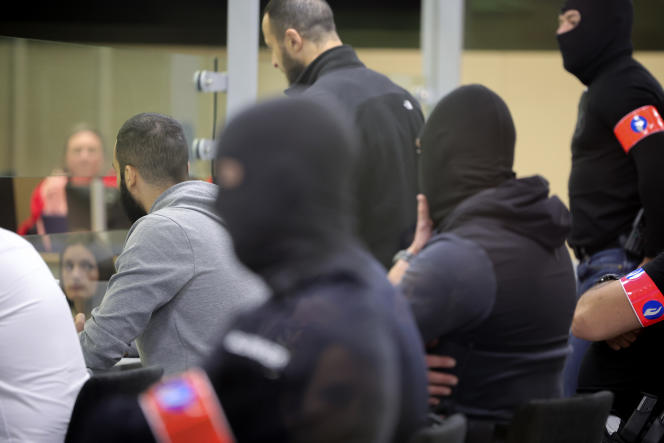 Les accusés et des agents de sécurité sont assis dans un espace en verre spécialement conçu, au procès des attentats djihadistes qui ont touché la capitale belge en 2016. A Bruxelles, le 25 juillet 2023.