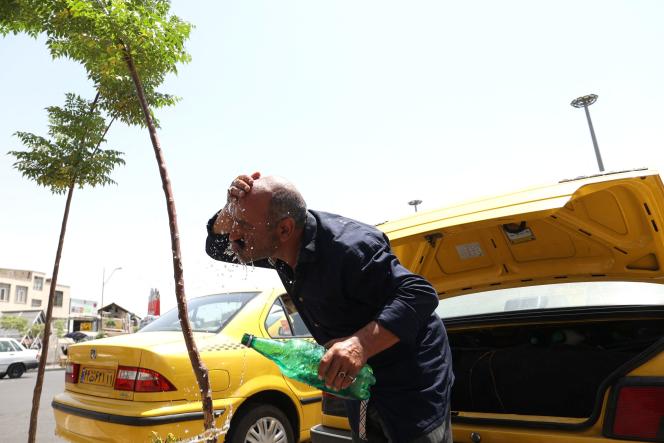 Un chauffeur de taxi iranien s’asperge d’eau pendant la vague de chaleur à Téhéran (Iran), le 2 août 2023.