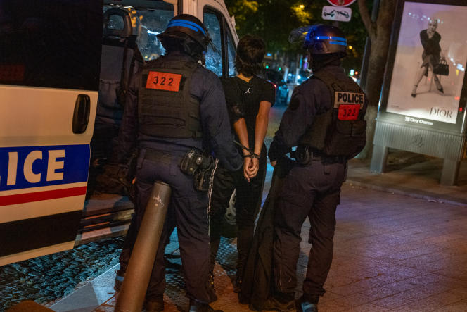 Un jeune homme arrêté par la police sur l’avenue des Champs Elysées, à Paris, dans la nuit du 1er au 2 juillet 2023.