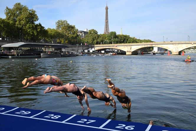 Des athlètes plongent dans les eaux de la Seine au niveau du pont Alexandre III, lors de l’épreuve de familiarisation à la natation à la veille d’un test de triathlon prévu à Paris, le 16 août 2023.
